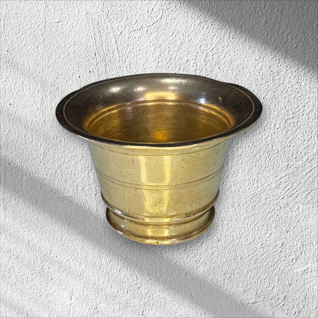 Mortero de bronce antiguo con maja decorativa, pieza rústica ideal para cocina tradicional o decoración vintage en hogar y jardín.