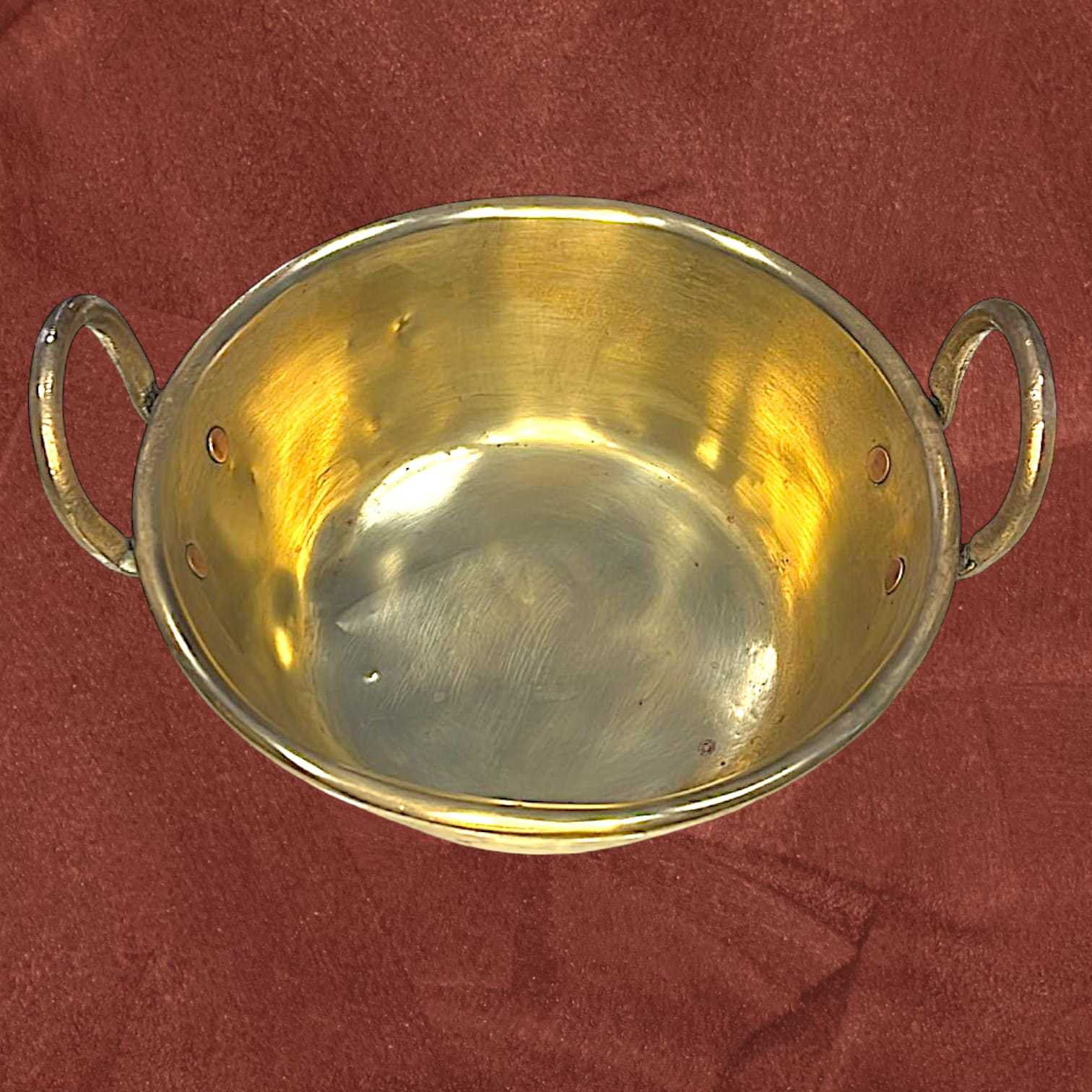 Vista superior del caldero antiguo de metal dorado con asas, acabado pulido y detalles únicos. Perfecto para decoración de hogar o jardín.