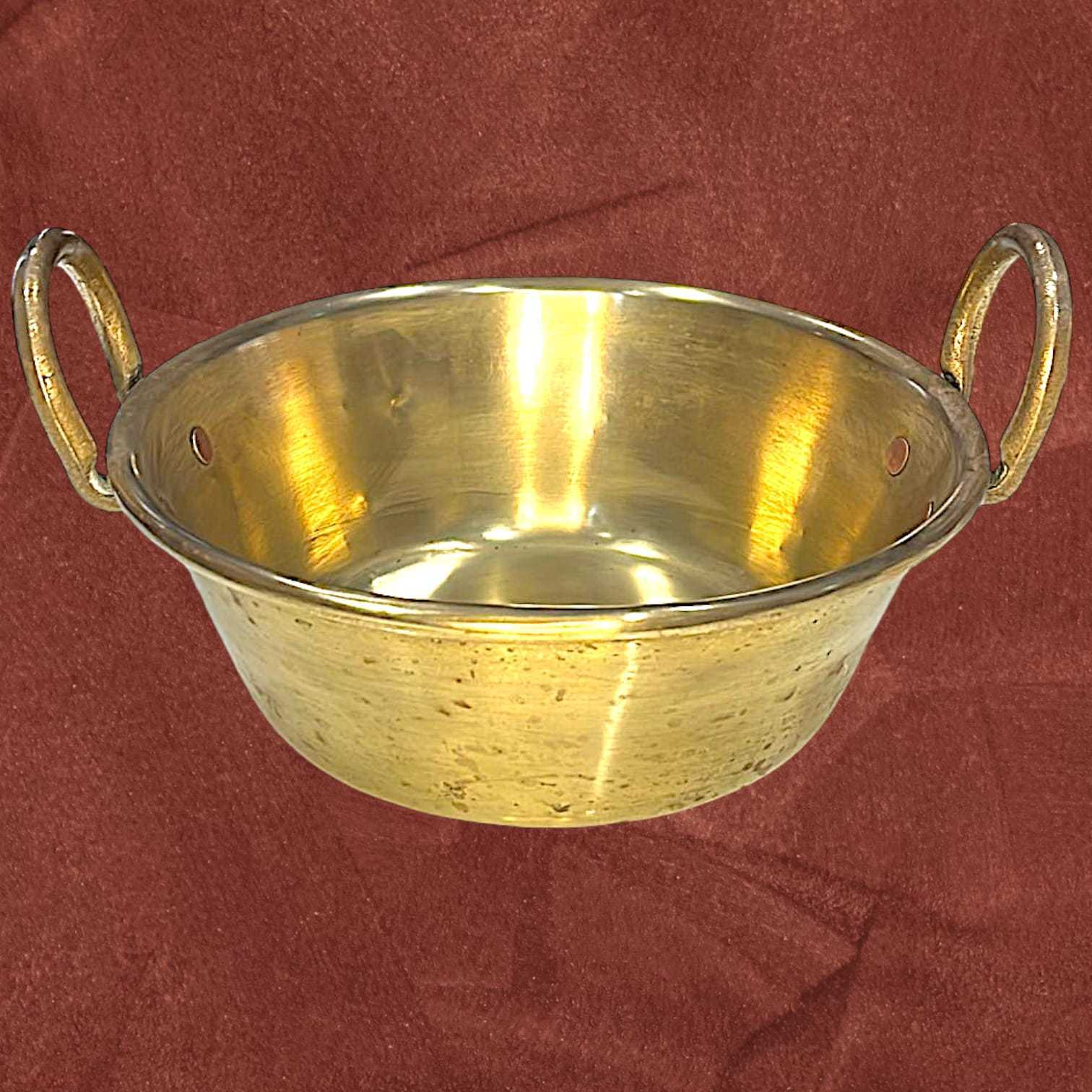 Caldero de metal dorado antiguo con asas laterales, diseño rústico perfecto para coleccionistas o decoración temática en interiores.