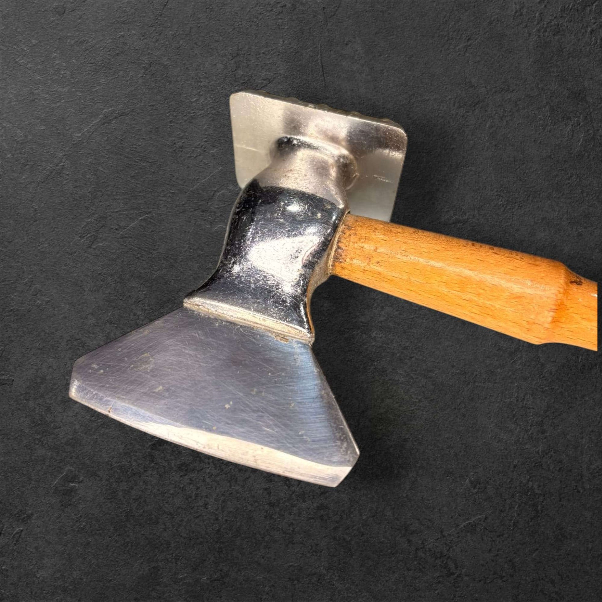 Detalle de la hoja de la hachuela de acero con mango de madera, pieza decorativa robusta para cocina estilo retro o colección temática.