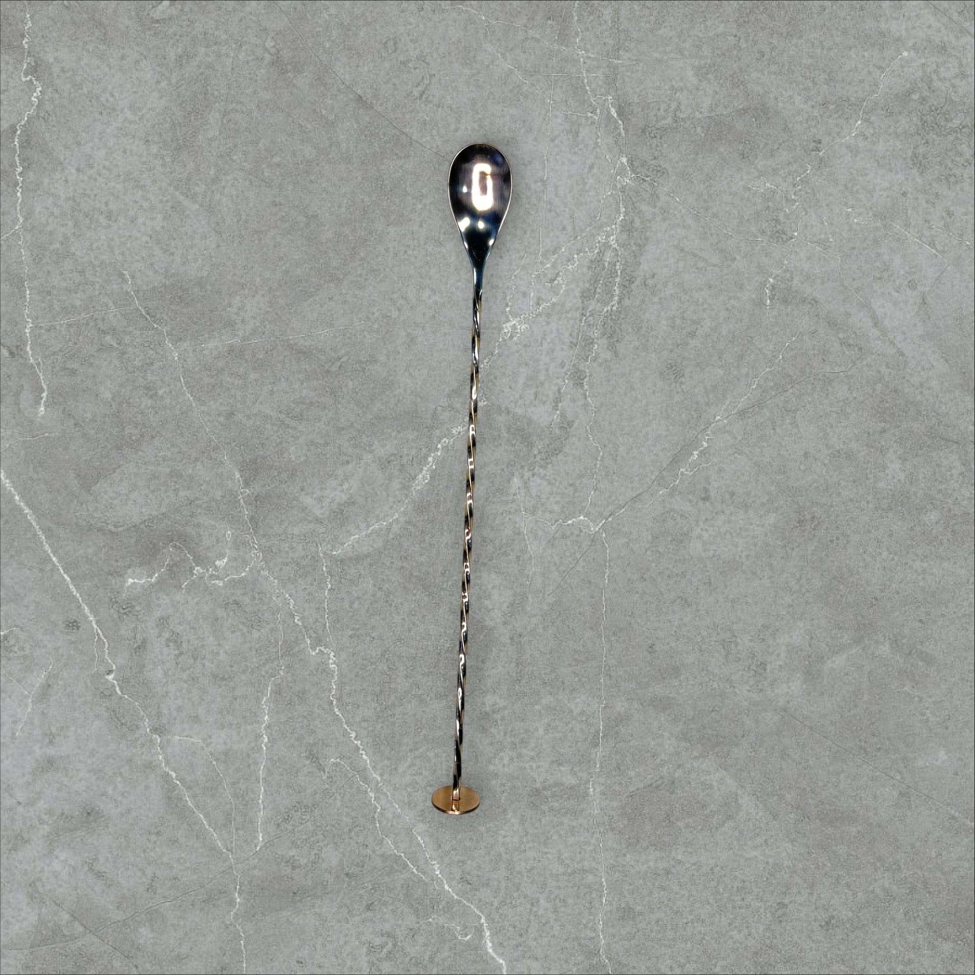 Vista frontal de cuchara de cóctel vintage de metal plateado, perfecta para complementar decoración de mesa y coctelería clásica.