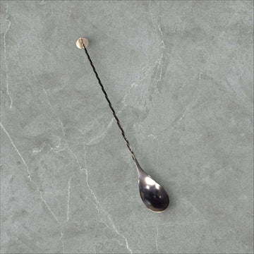 Cuchara de cóctel de metal plateado vintage con mango largo y espiral, ideal para decoración de bar en estilo retro elegante.