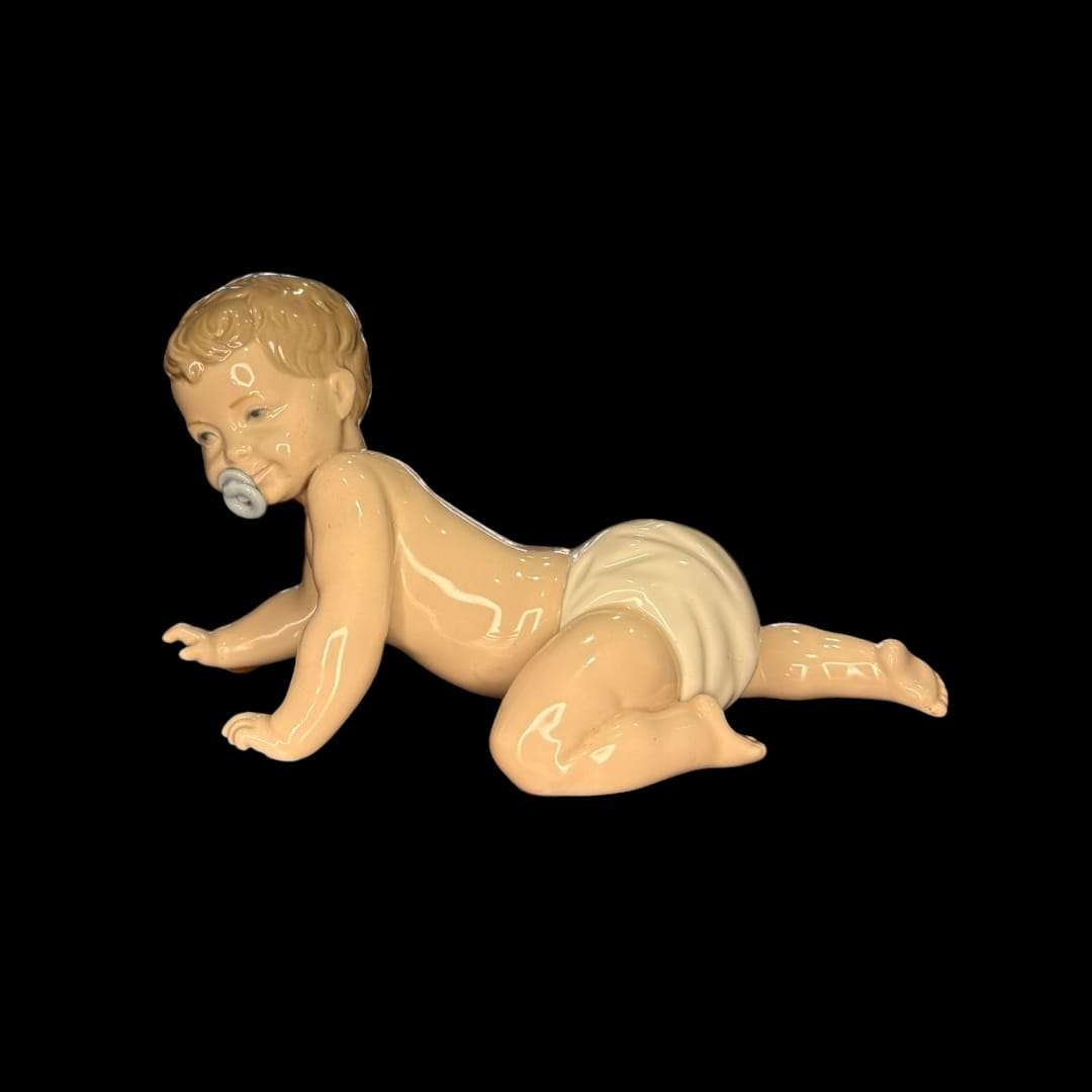 Figura de porcelana original Nao Lladró de bebé gateando con chupete, ideal para decoración del hogar o colección artística.