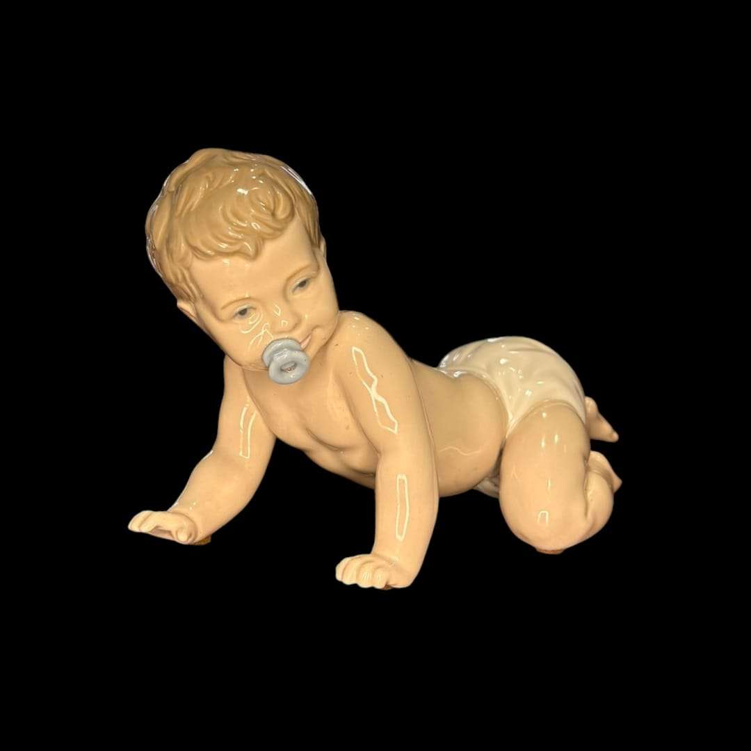 Figura de porcelana original Nao Lladró de bebé gateando con chupete, ideal para decoración del hogar o colección artística.