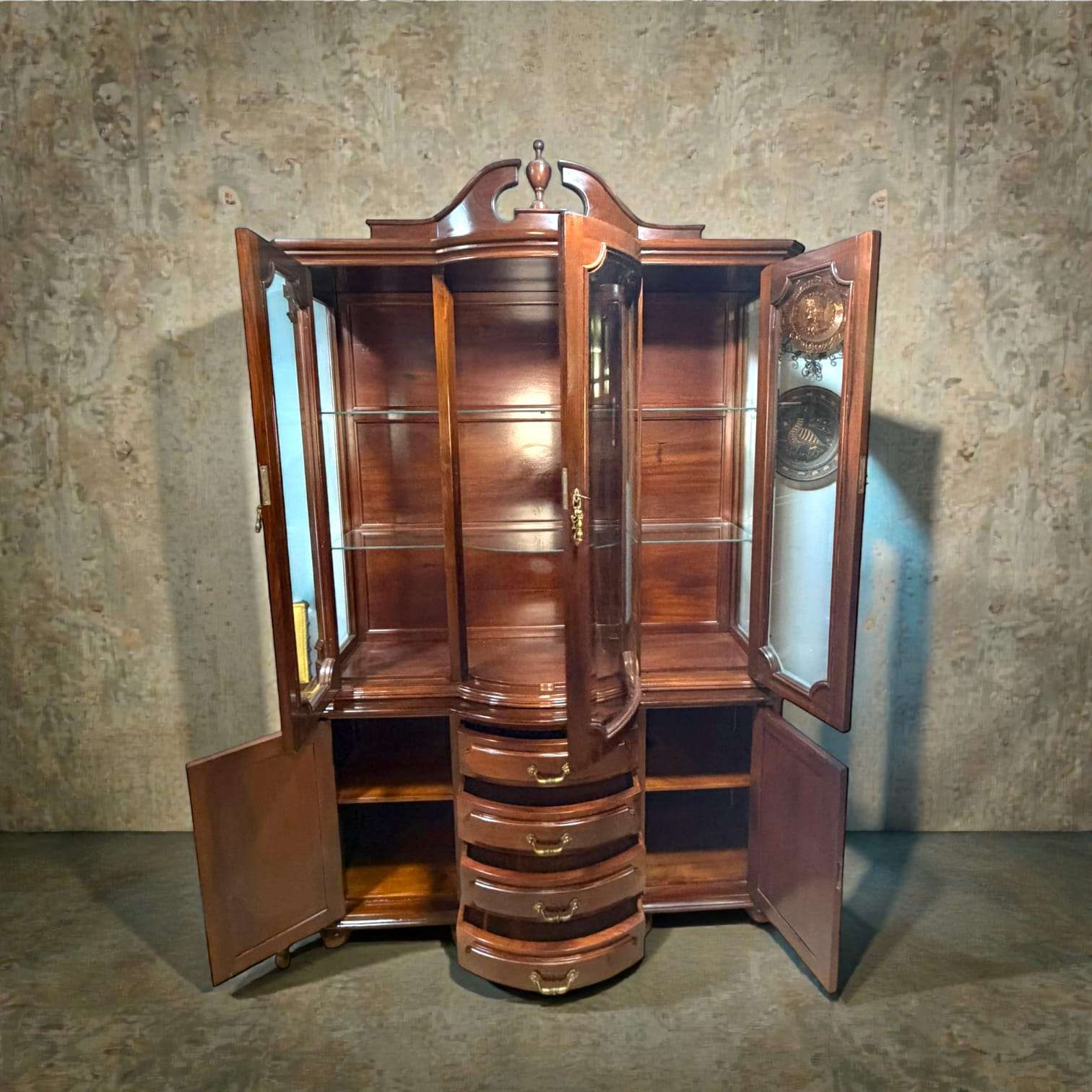 Vitrina de caoba clásica antigua con cristales biselados, puertas abiertas, estantes de exhibición y cajones curvos. Ideal para decoración de salón.