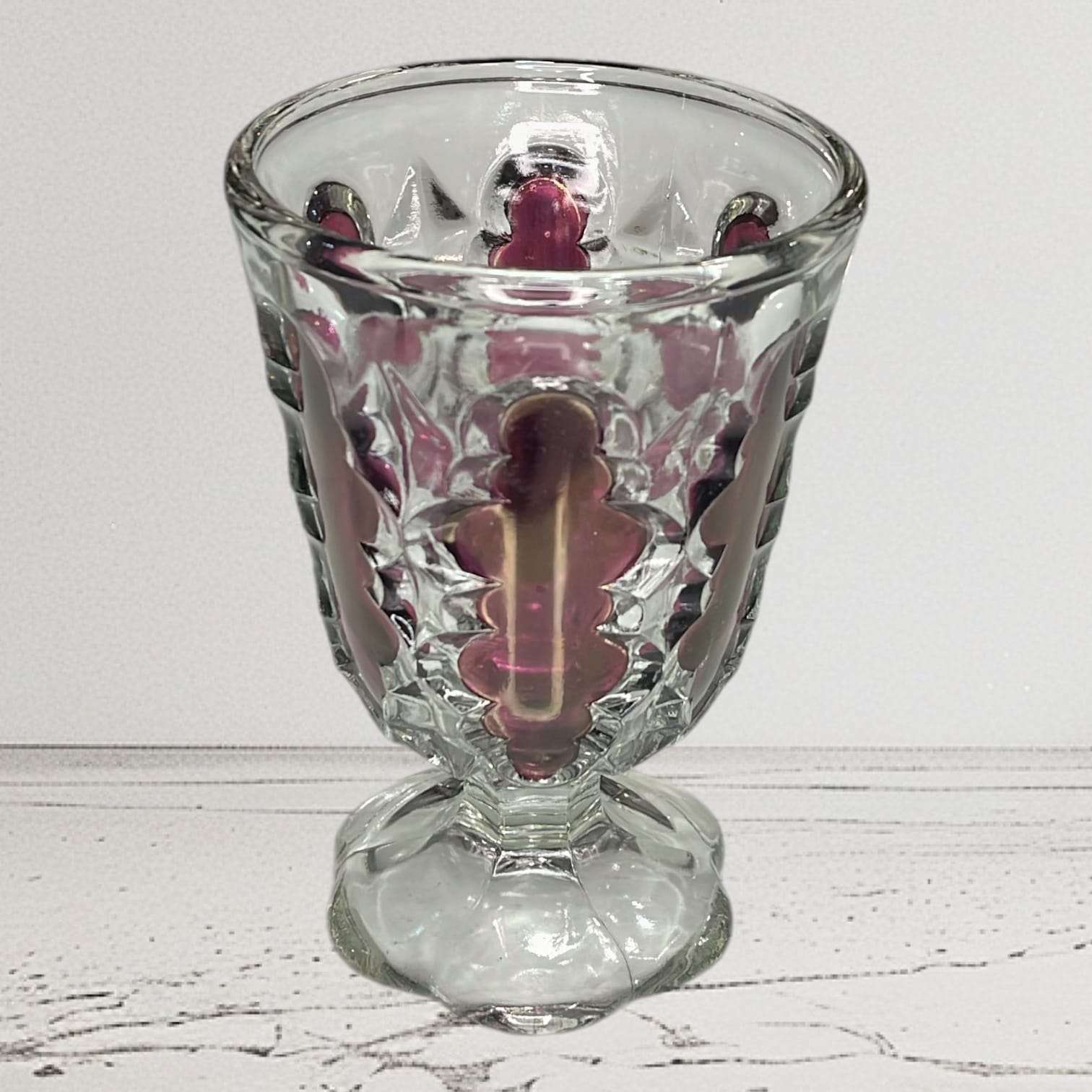 Copa de cristal rubí antigua de vidrio prensado con detalles decorativos en relieve, típica de los siglos XIX–XX. Ideal para decoración vintage en el hogar.