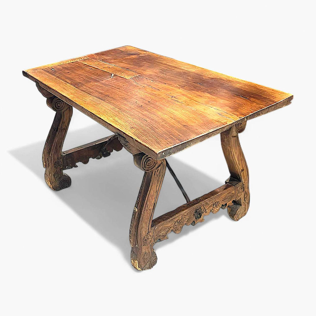 Mesa Castellana antigua de madera maciza con patas talladas en forma de lira. Ideal para decoración rústica en comedores con estilo histórico.