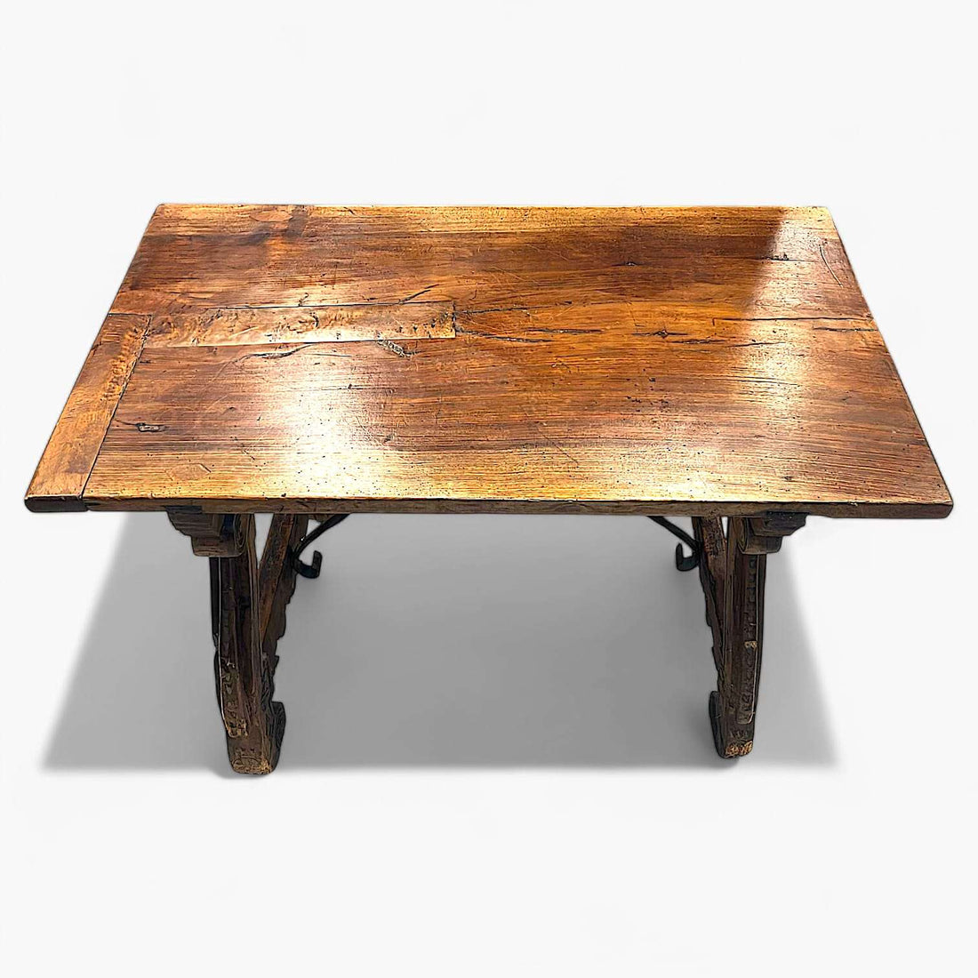 Mesa Castellana antigua de madera maciza con patas talladas en forma de lira. Ideal para decoración rústica en comedores con estilo histórico.