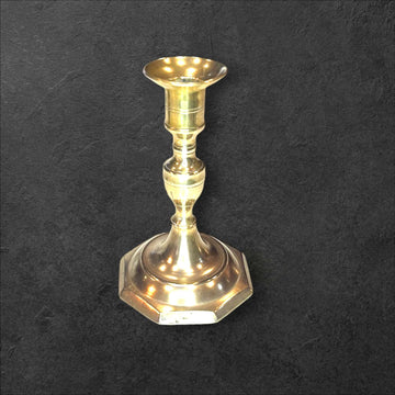 Candelabro de bronce clásico con base octagonal sobre fondo oscuro, ideal para decoración tradicional en interiores elegantes.