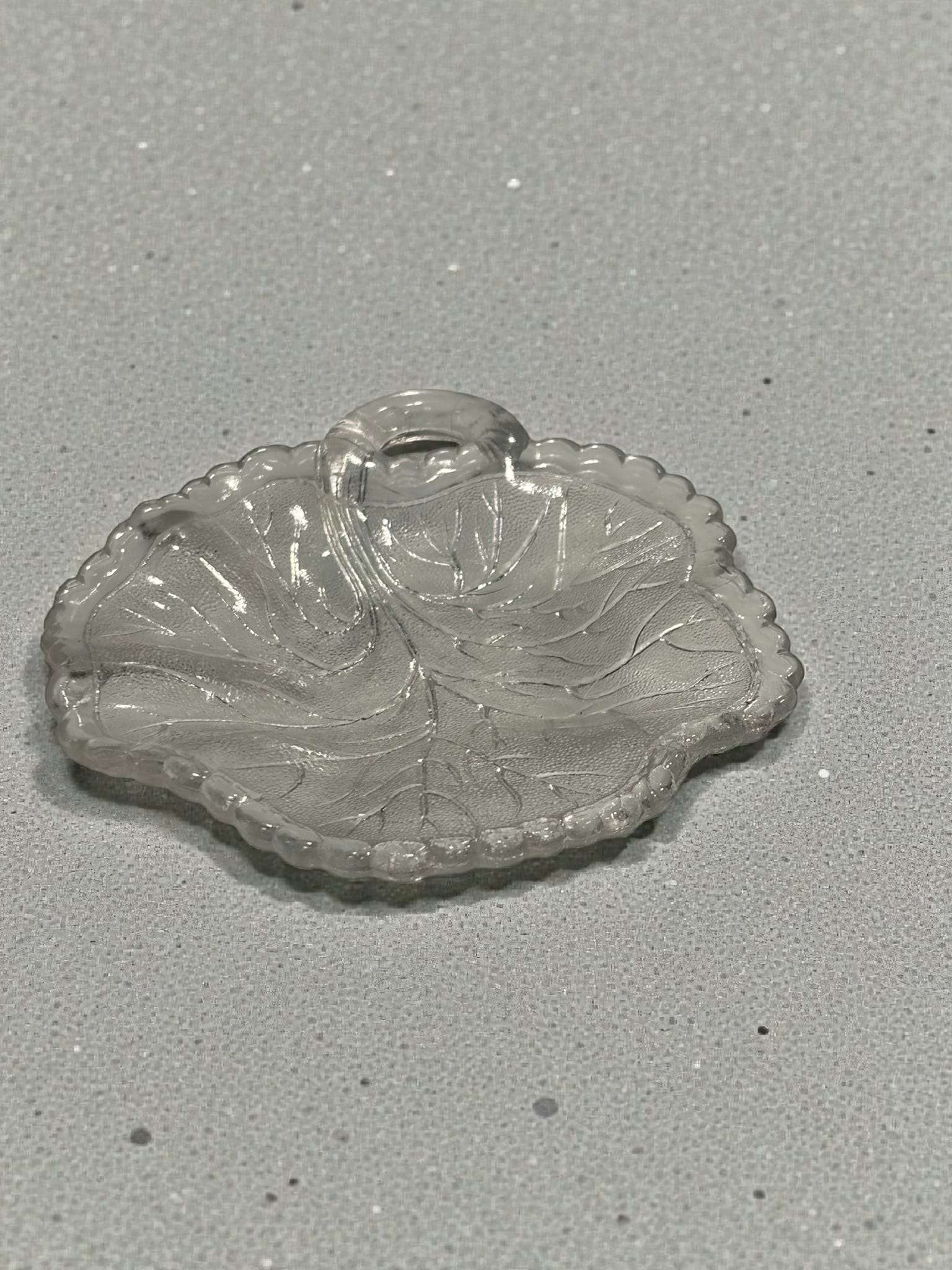 Plato decorativo de cristal prensado con diseño de hoja y borde ondulado, parte del lote de platos de cristal antiguos.