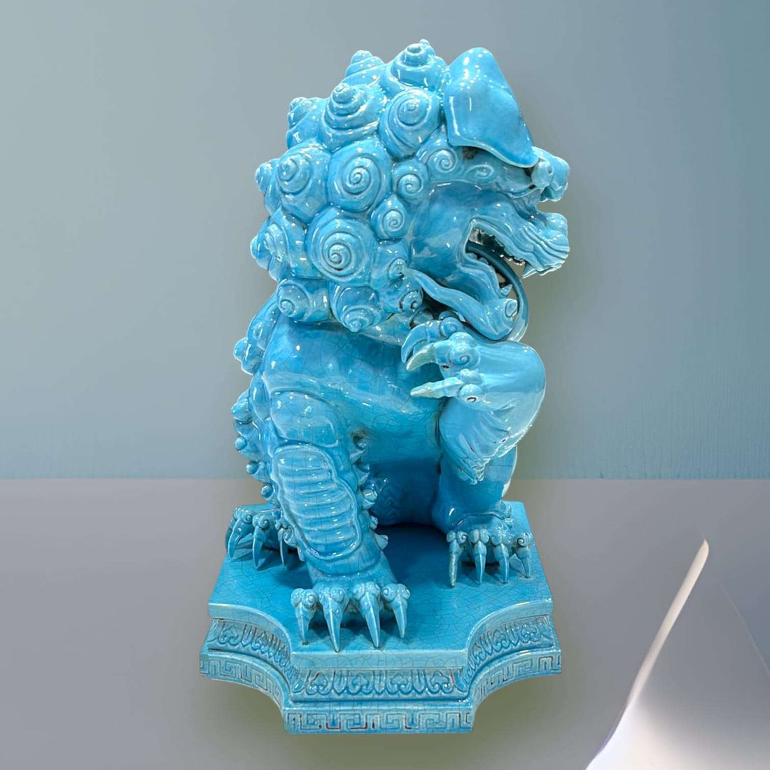 León Foo de Porcelana Turquesa con detalles ornamentales, símbolo de protección ancestral para decoración en interiores elegantes.