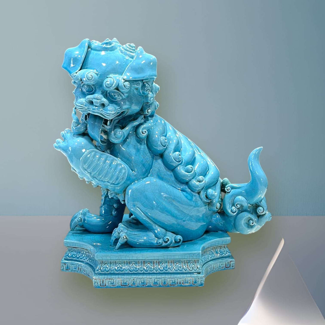 León Foo de Porcelana Turquesa con detalles ornamentales, símbolo de protección ancestral para decoración en interiores elegantes.