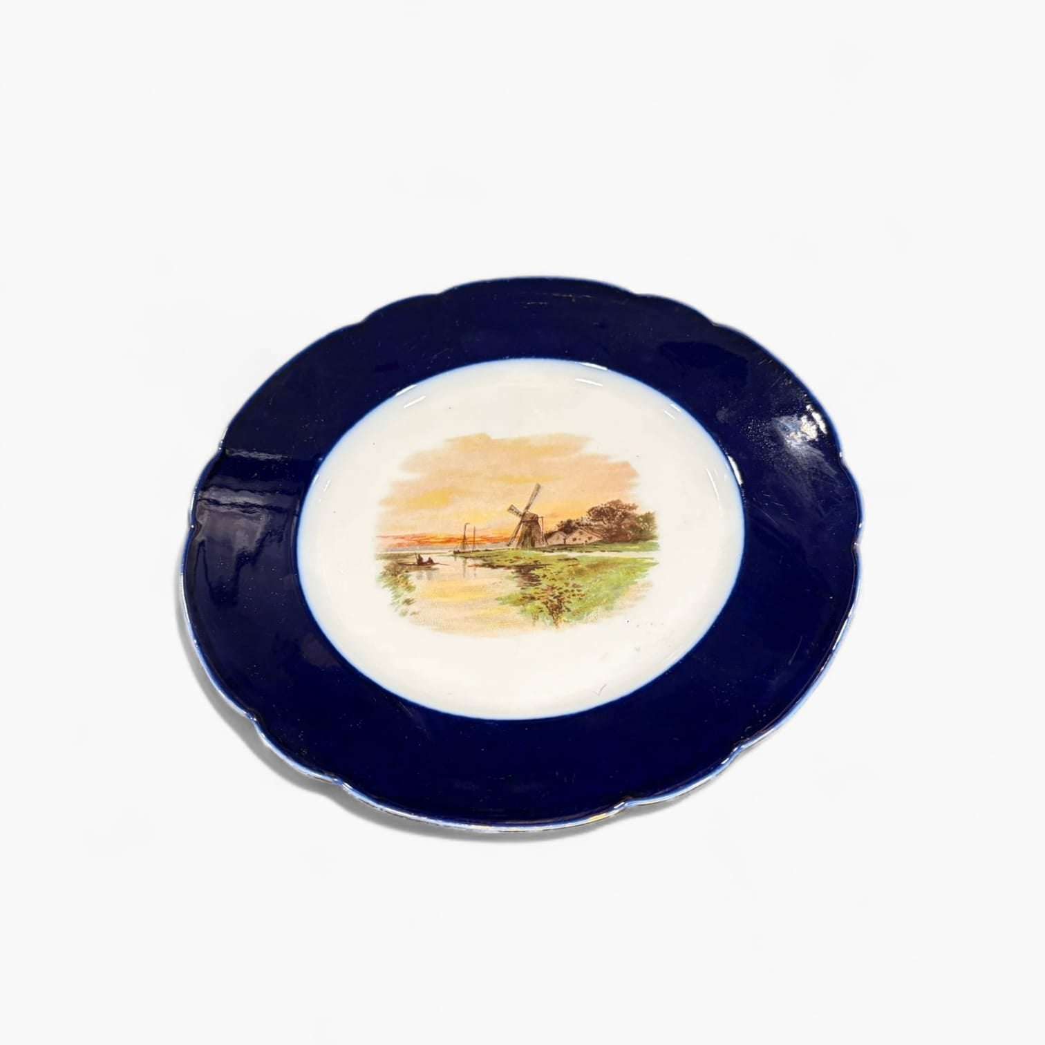 Decoración de hogar con plato de porcelana Limoges antiguo pintado a mano, diseño francés con escena campestre y borde azul oscuro.
