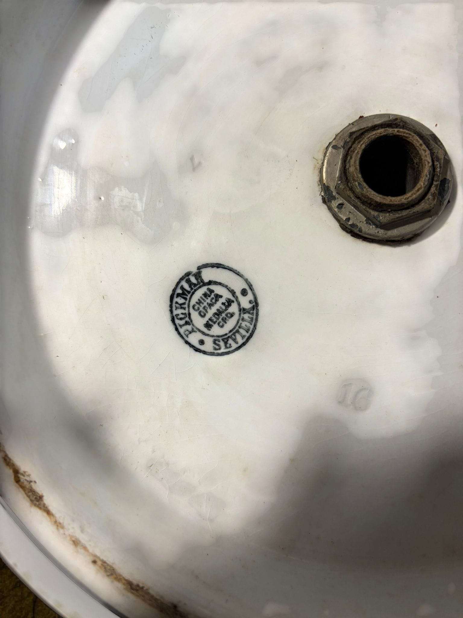 Sello original Pickman Sevilla en la base del lavabo de loza antiguo, certificando su autenticidad como pieza única de cerámica decorativa.