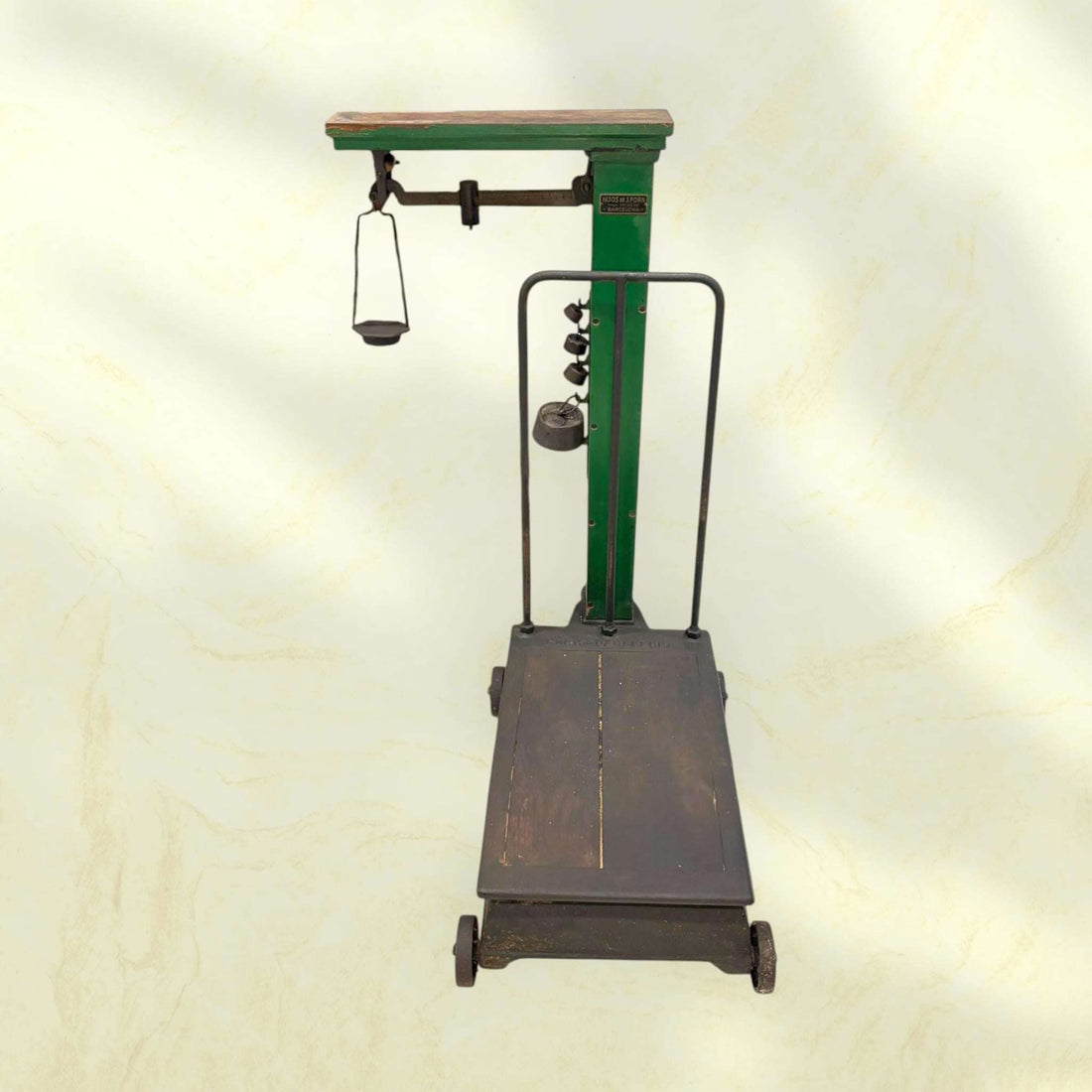 Báscula antigua mecánica de plataforma industrial clásica con estructura verde y base de madera oscura. Ideal para decoración vintage en espacios rústicos.