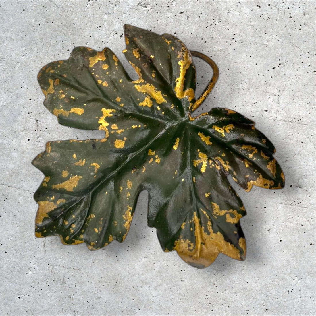 Conjunto de hojas decorativas de metal vintage doradas y verdes con acabado envejecido sobre fondo gris. Ideal para decoración artística del hogar.