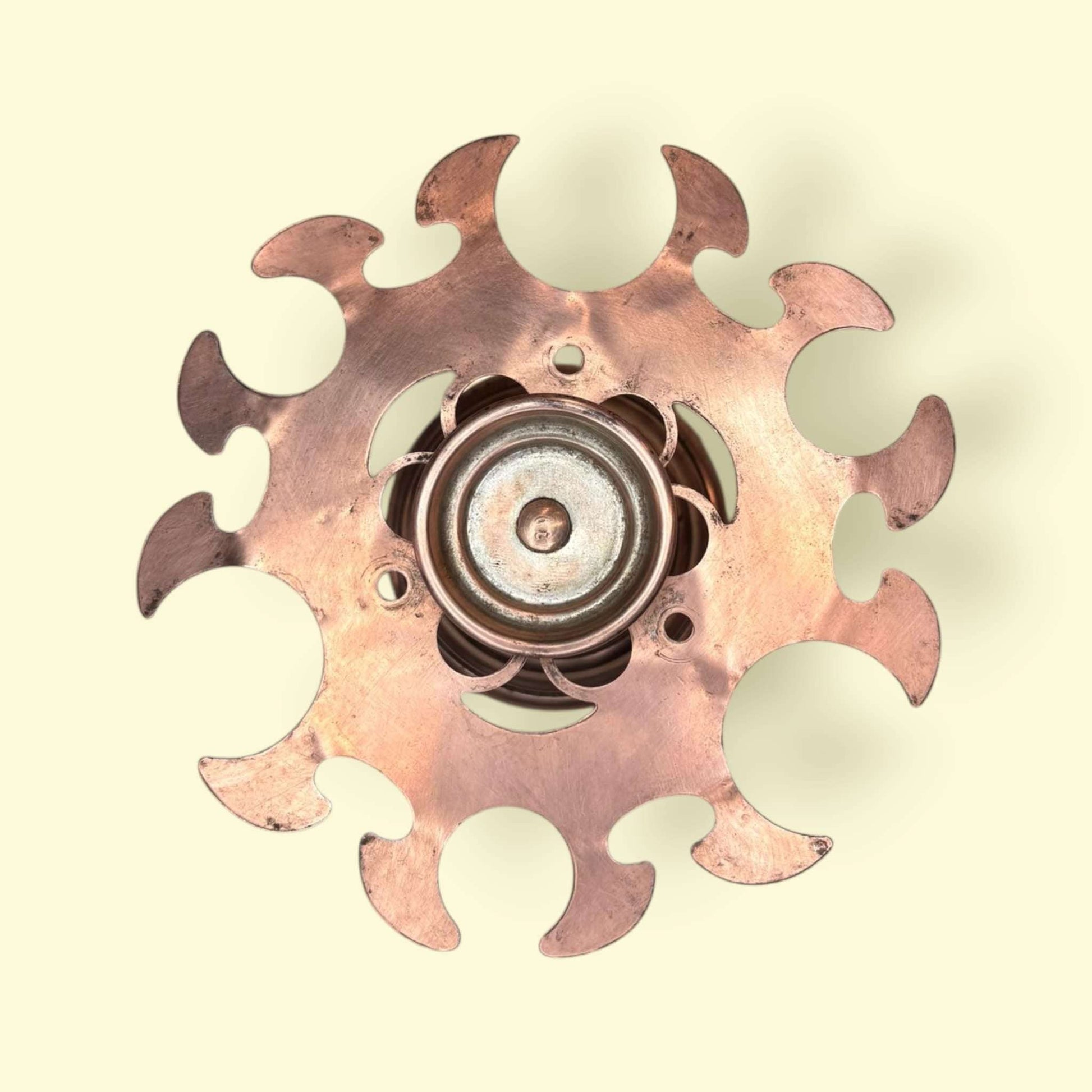 Vista superior del soporte para copas de cobre antiguo con diseño radial, ideal como pieza decorativa en interiores de estilo retro o rústico.