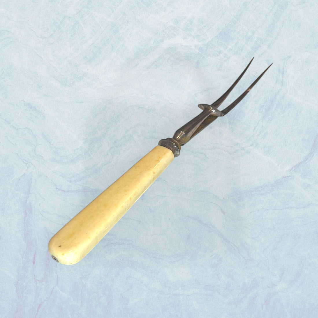 Tenedor de trinchar antiguo clásico único y decorativo con mango beige y púas metálicas, ideal para decoración vintage en comedor o cocina.