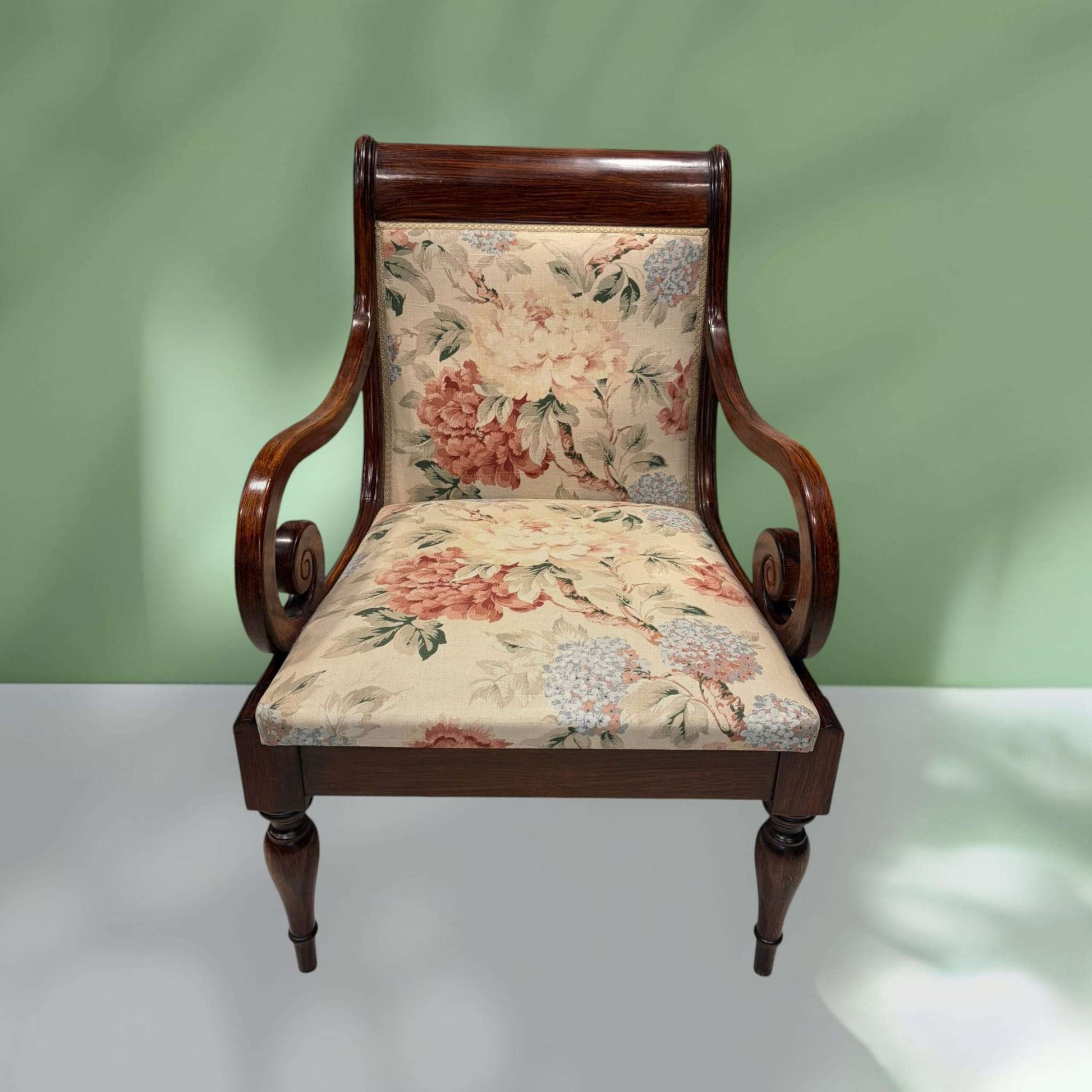 Sillón de madera con brazos curvos y tapizado floral clásico, diseño decorativo perfecto para espacios de estilo tradicional.