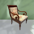 Sillón clásico de madera con brazos tallados y asiento tapizado en flores, ideal para decoración de interiores con encanto retro.