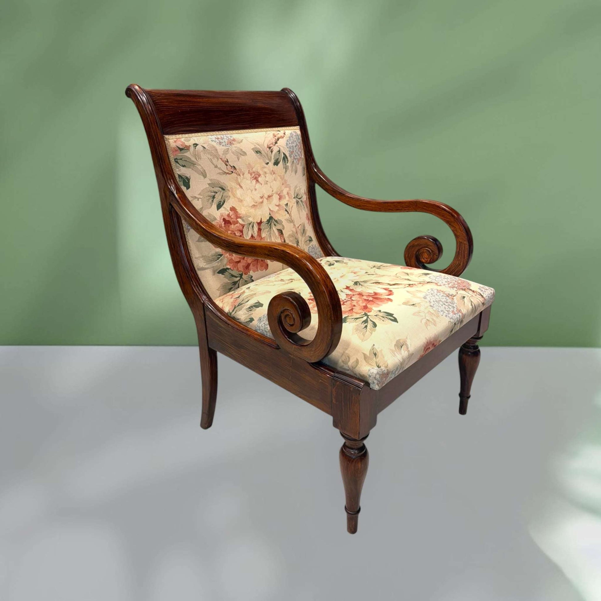 Sillón clásico de madera con brazos tallados y asiento tapizado en flores, ideal para decoración de interiores con encanto retro.