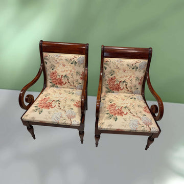 Pareja de sillones de madera con brazos clásicos y tapizado floral único, ideales para decoración elegante en interiores vintage.