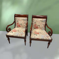 Conjunto de sillones de madera con brazos curvos y tapizado floral, perfectos para decoración clásica en hogar o jardín interior.
