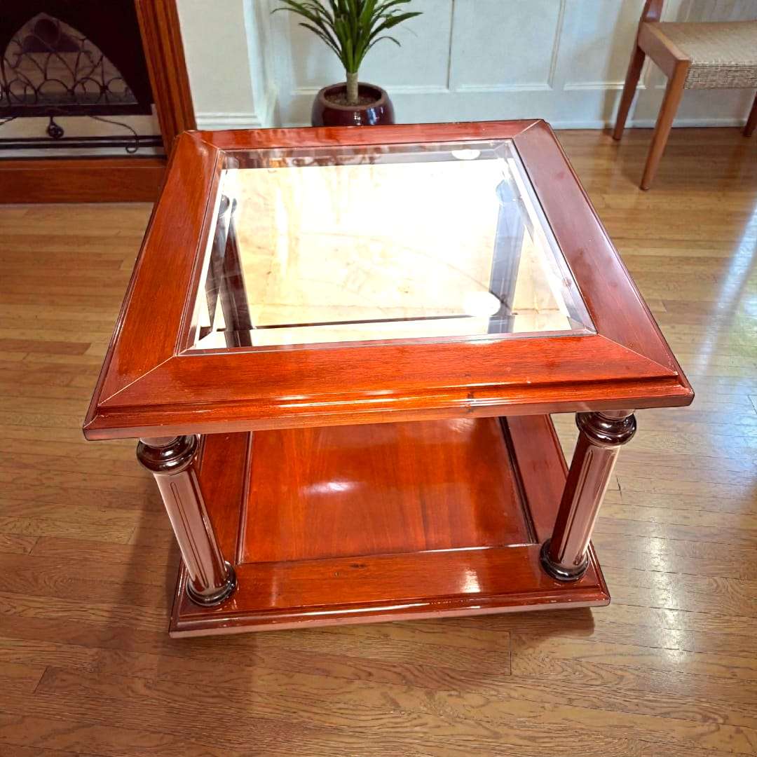Mesa auxiliar cuadrada de caoba con cristal biselado y columnas decorativas, ideal para decoración de interiores sofisticados.