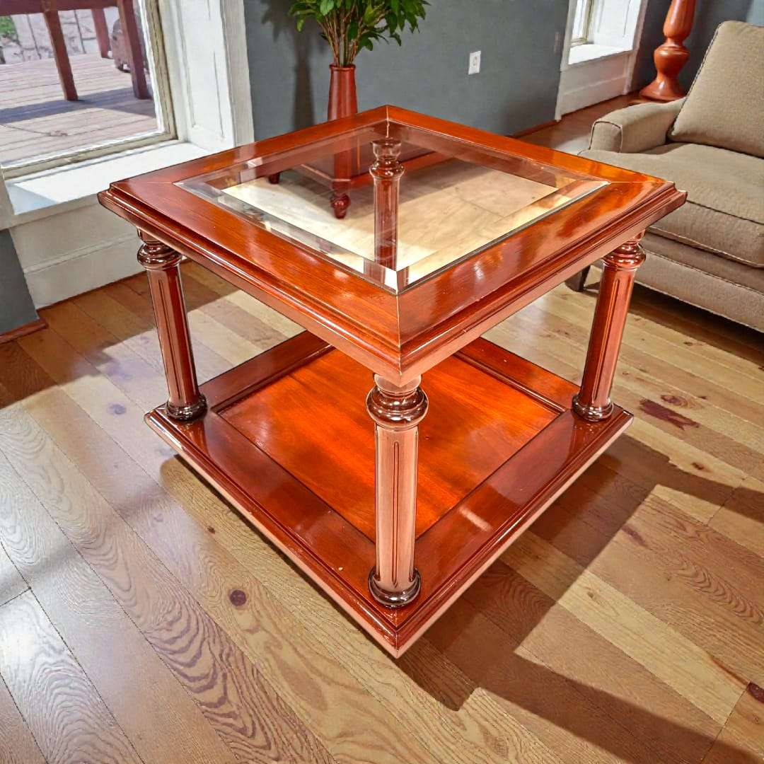 Mesa baja de caoba con tapa de cristal biselado y estante inferior, perfecta para salones con estilo clásico y elegante.