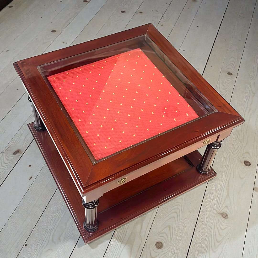 Mesa expositora de caoba con cristal biselado - Vintage con cajón tapizado en rojo y detalles dorados. Ideal para decoración clásica en el hogar.