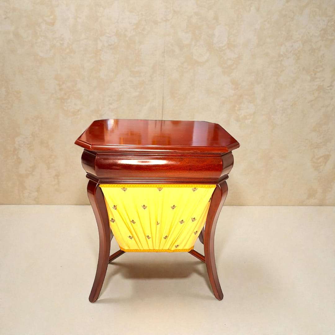 Costurero de caoba clásico con compartimentos, tapa abatible y faldón amarillo decorado. Ideal para decoración vintage en hogar elegante.