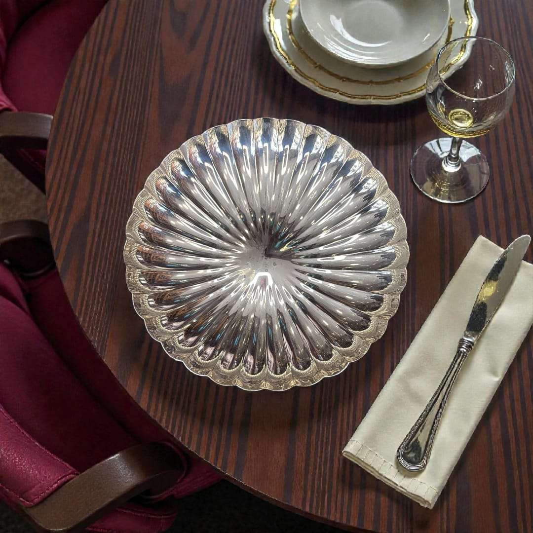 Panera de metal plateado 27 cm diseño acanalado en mesa de restaurante