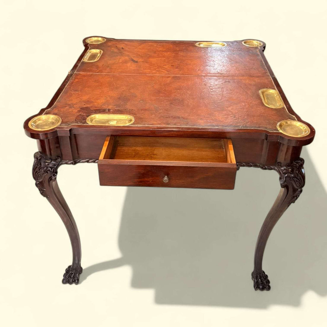 Mesa de juego antigua de madera con aplicaciones en metal dorado y patas de garra talladas