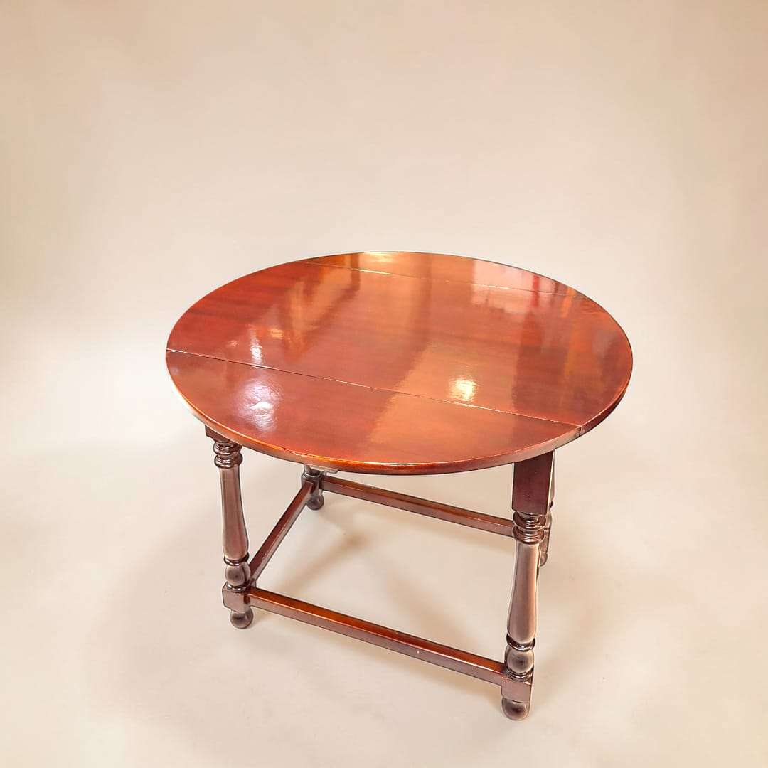 Esta Mesa antigua de caoba con alas plegables es una pieza funcional y elegante diseñada para adaptarse a diferentes espacios y momentos del hogar.