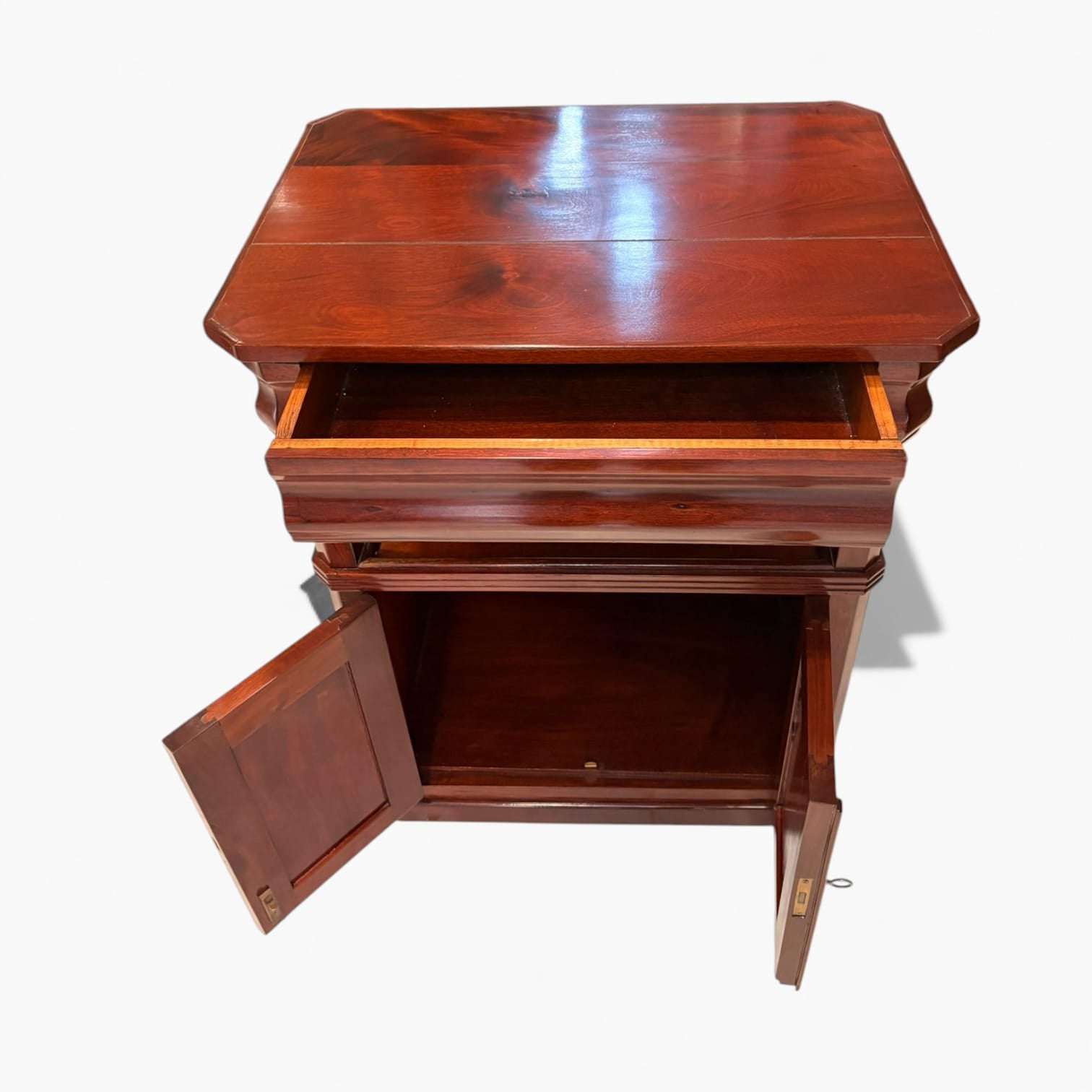 Esta mesa auxiliar de caoba destaca por su belleza serena, por el brillo profundo de la madera y por una si