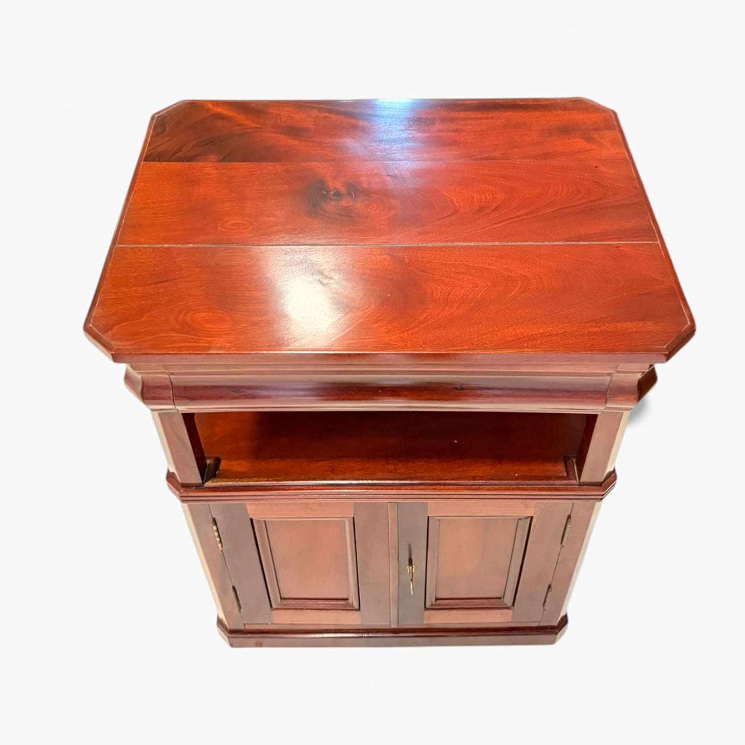 Esta mesa auxiliar de caoba destaca por su belleza serena, por el brillo profundo de la madera y por una si