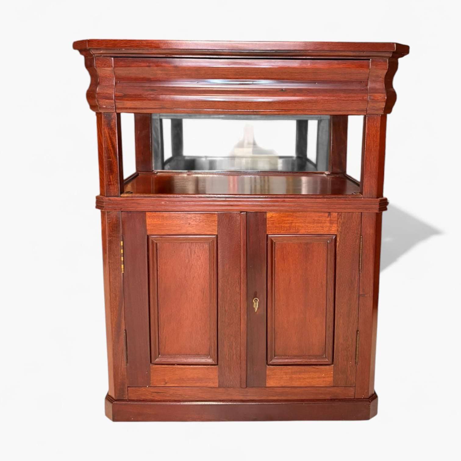 Esta mesa auxiliar de caoba destaca por su belleza serena, por el brillo profundo de la madera y por una si