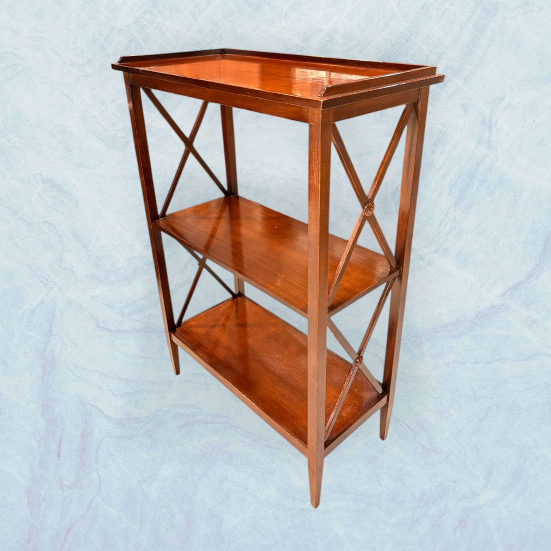 La Mesa estantería de caoba es una pieza auxiliar elegante que combina funcionalidad y valor decorativo en un formato compacto y equilibrado. 