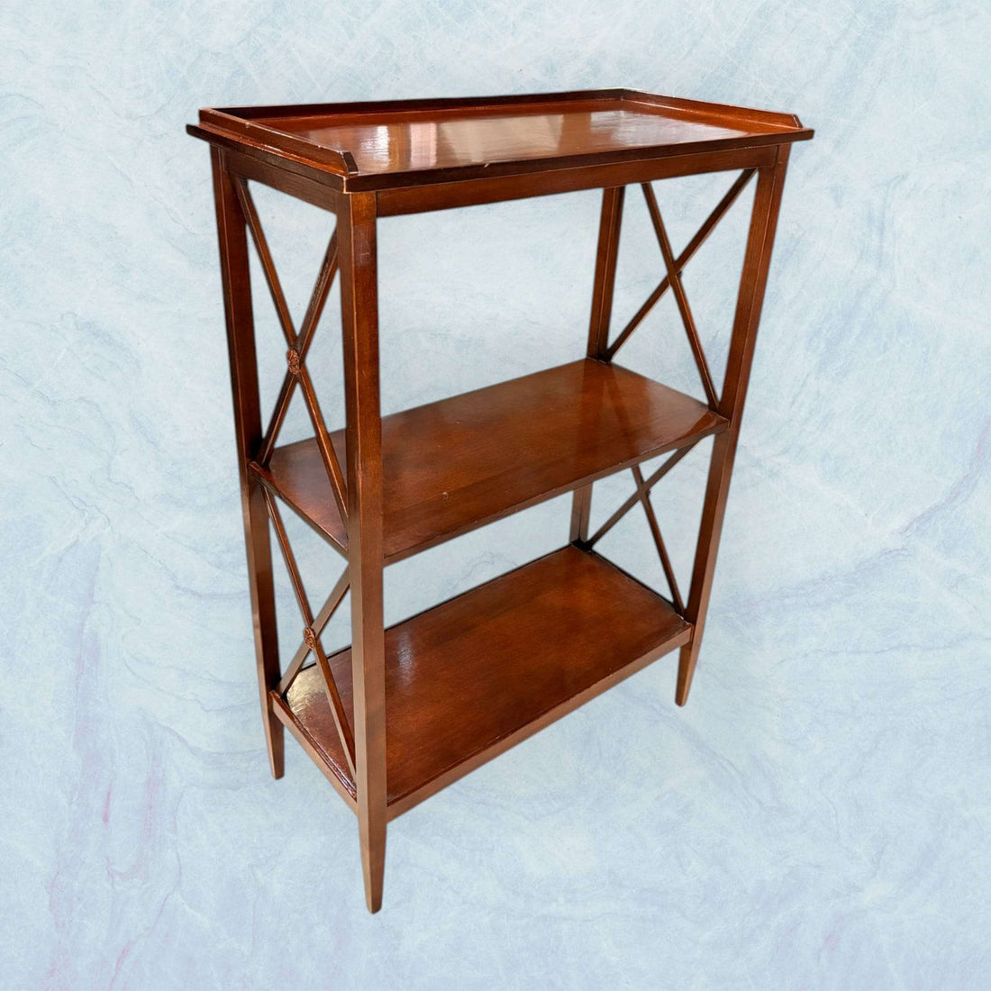 La Mesa estantería de caoba es una pieza auxiliar elegante que combina funcionalidad y valor decorativo en un formato compacto y equilibrado. 