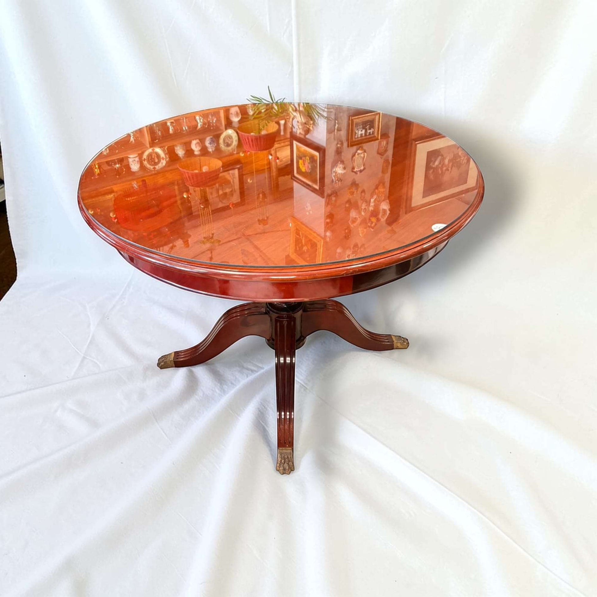 Hoy, además de conservar toda su utilidad, esta Mesa redonda de caoba con tapa de cristal destaca como pieza decorativa por derecho propio. 