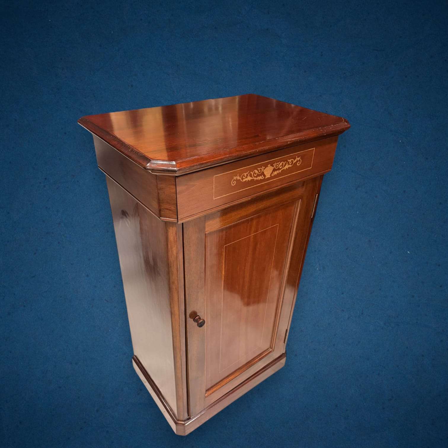 El Zapatero de caoba con taraceas es una pieza antigua concebida para mantener el calzado ordenado y resguardado, al mismo tiempo que aporta una presencia elegante al espacio.