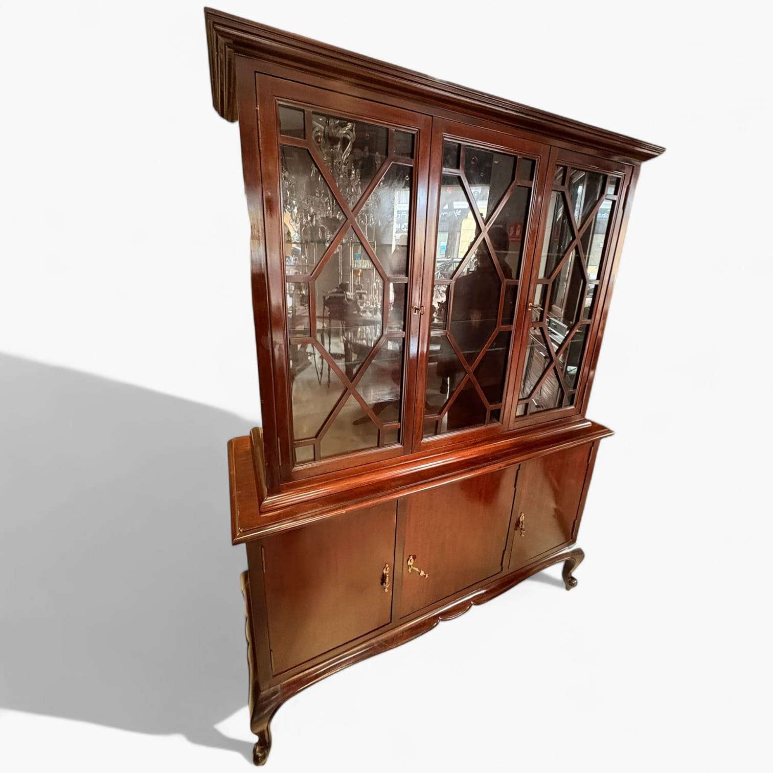 La Vitrina de caoba es una pieza concebida para cumplir una doble función: exponer objetos valiosos o decorativos en la parte superior y mantener almacenaje cerrado en la parte inferior. 