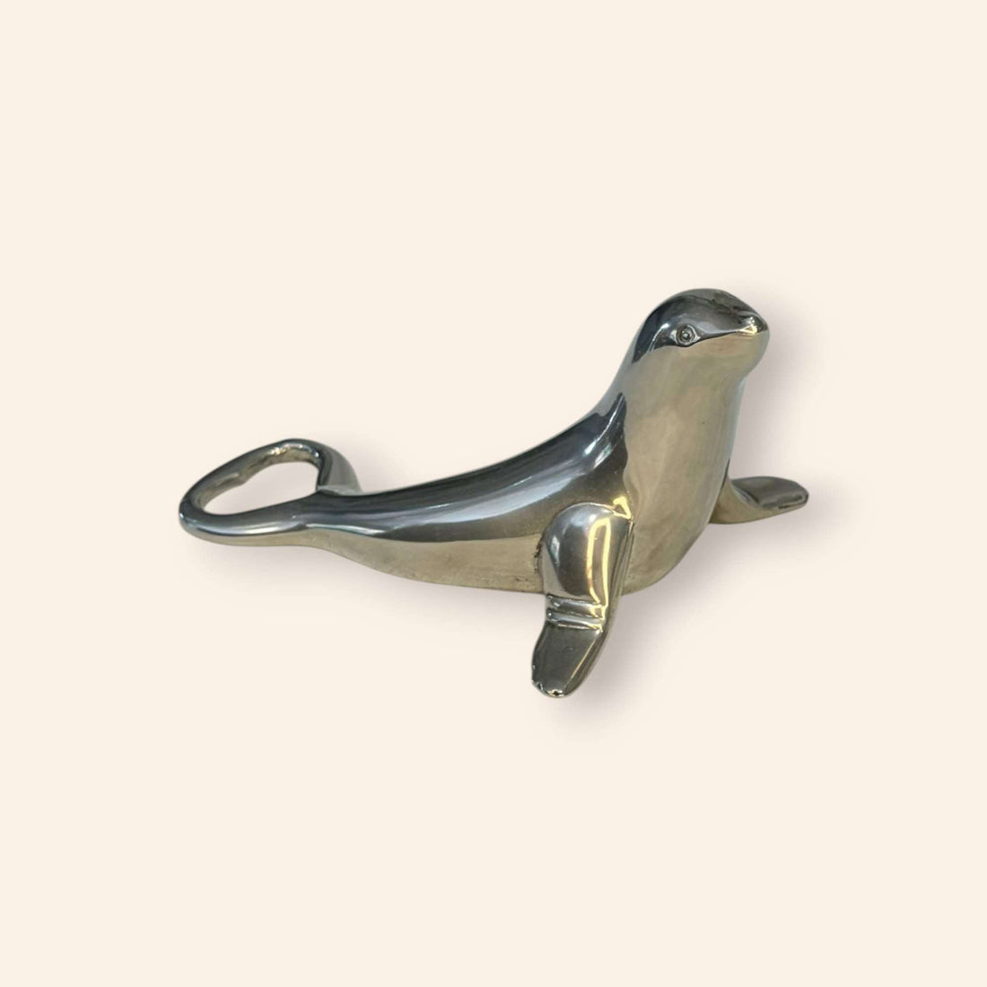 Este abridor de botellas de metal plateado con forma de foca es una pieza tan práctica como decorativa, creada para abrir chapas de botellas de forma cómoda y convertir un gesto cotidiano en un detalle con encanto. 