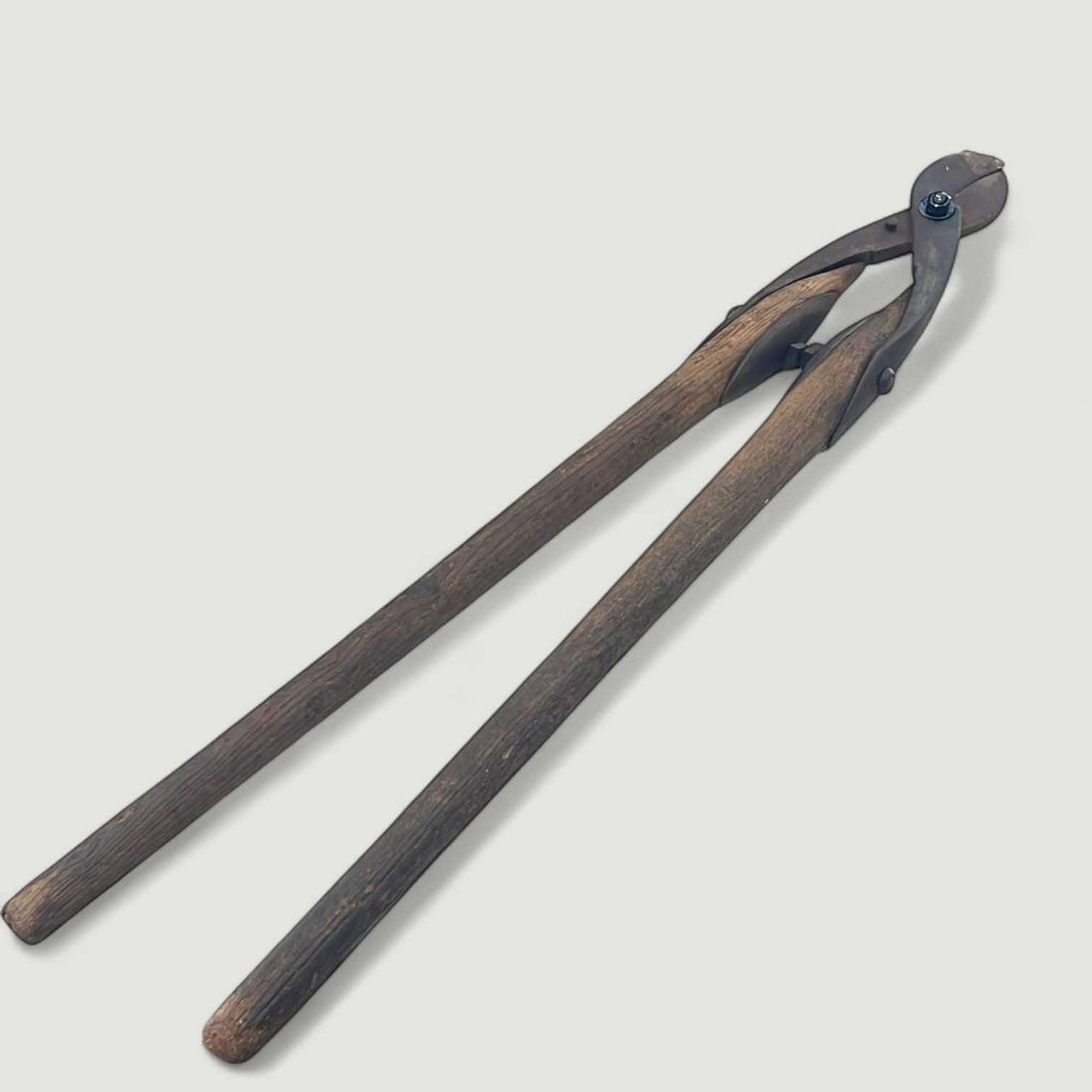 Esta herramienta antigua para cortar ramas fue concebida para una función clara y contundente: facilitar el corte de ramas mediante un sistema manual de gran palanca. 