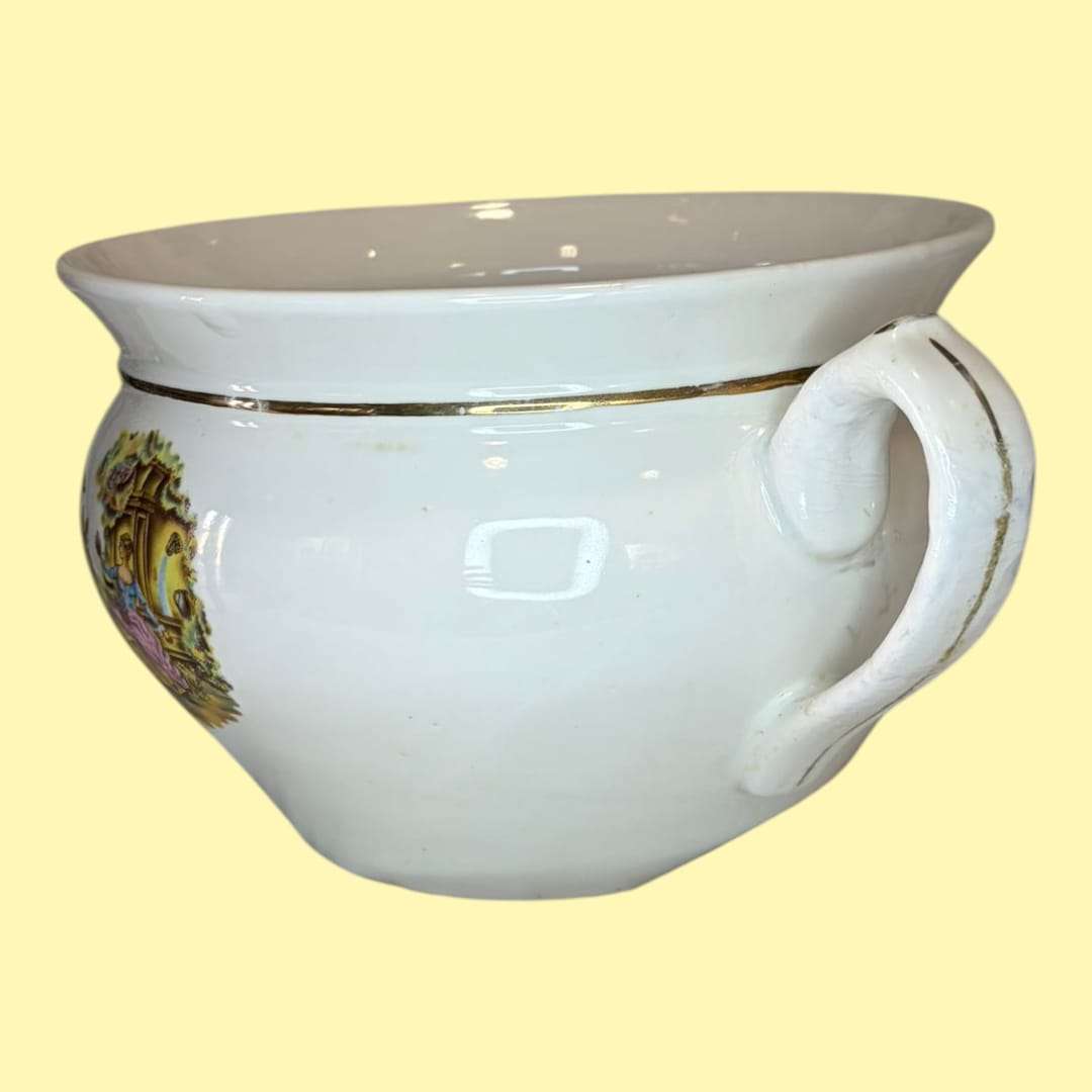 Este Orinal de porcelana está realizado en porcelana blanca vidriada, con una presencia limpia y luminosa que contrasta con la delicadeza del motivo decorativo. 