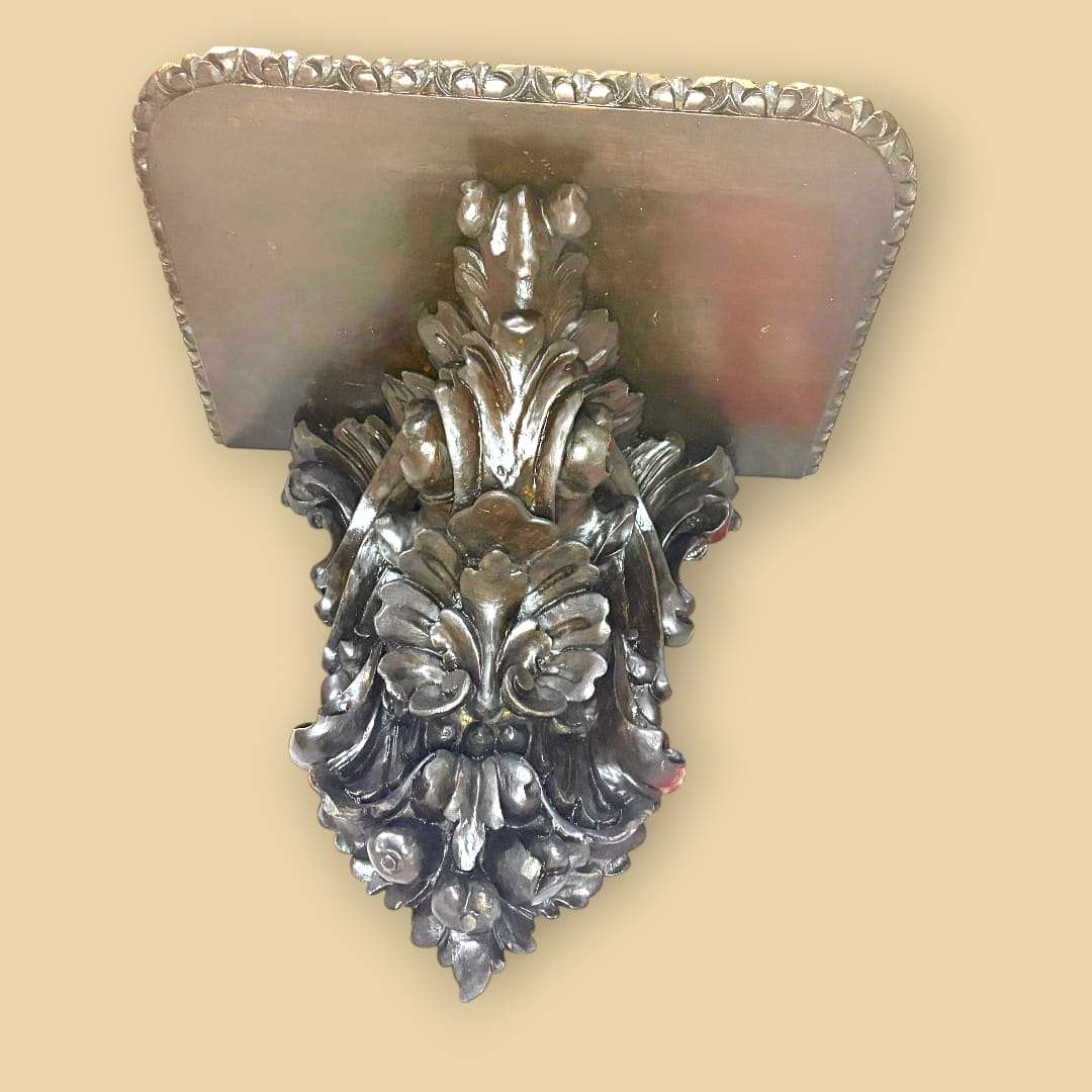 En las imágenes se aprecia una estructura de fuerte inspiración historicista, con una balda superior rectangular de esquinas suavemente redondeadas y un perímetro tallado.