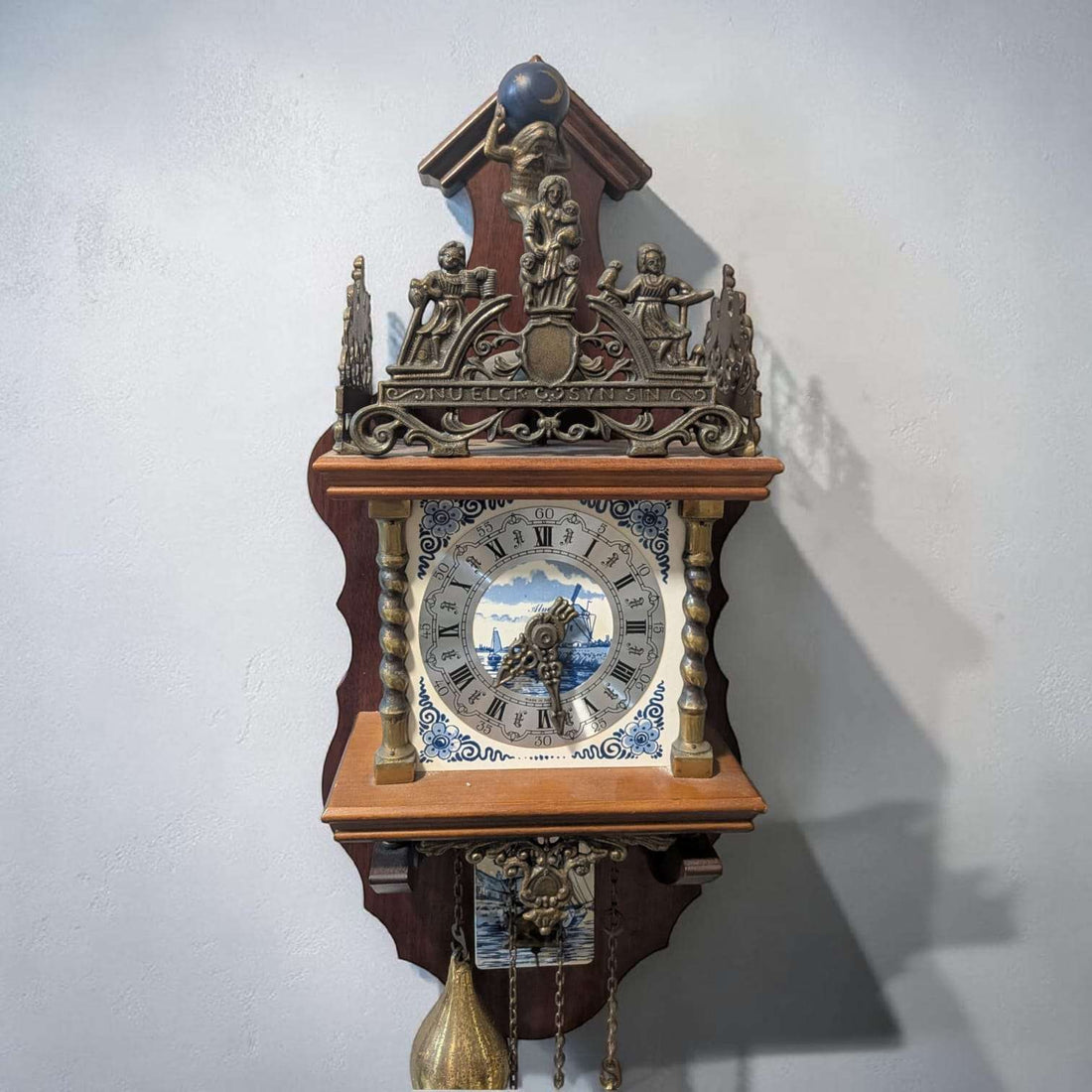 Reloj antiguo de madera y metal decorativo de pared en interior de hogar