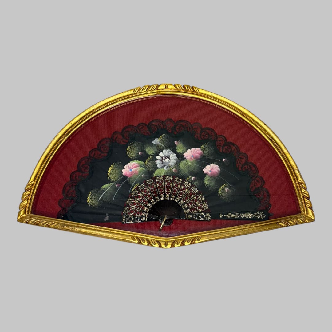 En su interior, esta Abaniquera alberga un abanico negro decorativo, con delicados motivos florales en tonos suaves que contrastan de forma elegante sobre el fondo oscuro. 