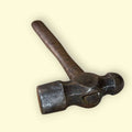 Este martillo de bola antiguo representa la esencia de la herramienta tradicional, combinando funcionalidad real con un fuerte valor estético y decorativo. 