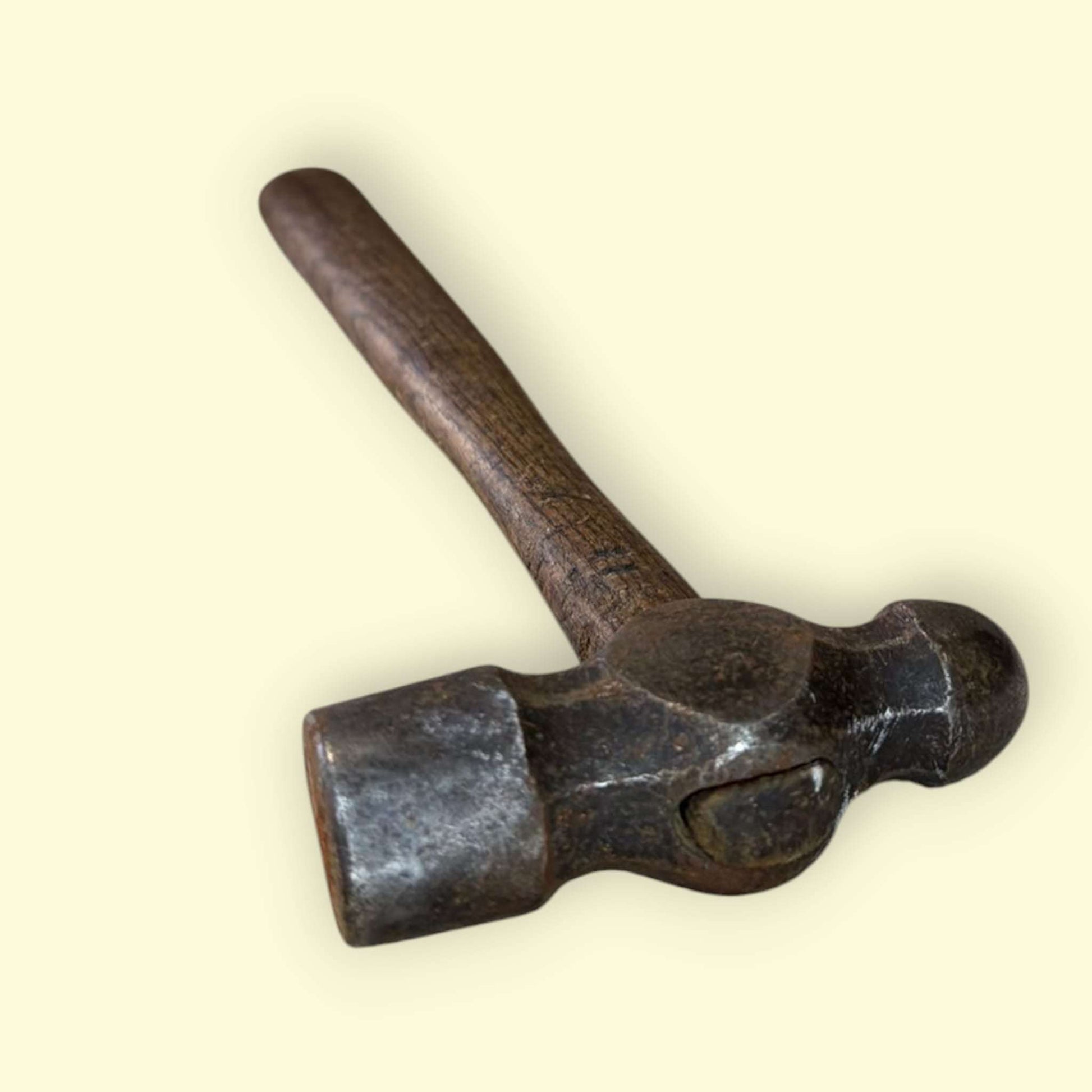 Este martillo de bola antiguo representa la esencia de la herramienta tradicional, combinando funcionalidad real con un fuerte valor estético y decorativo. 